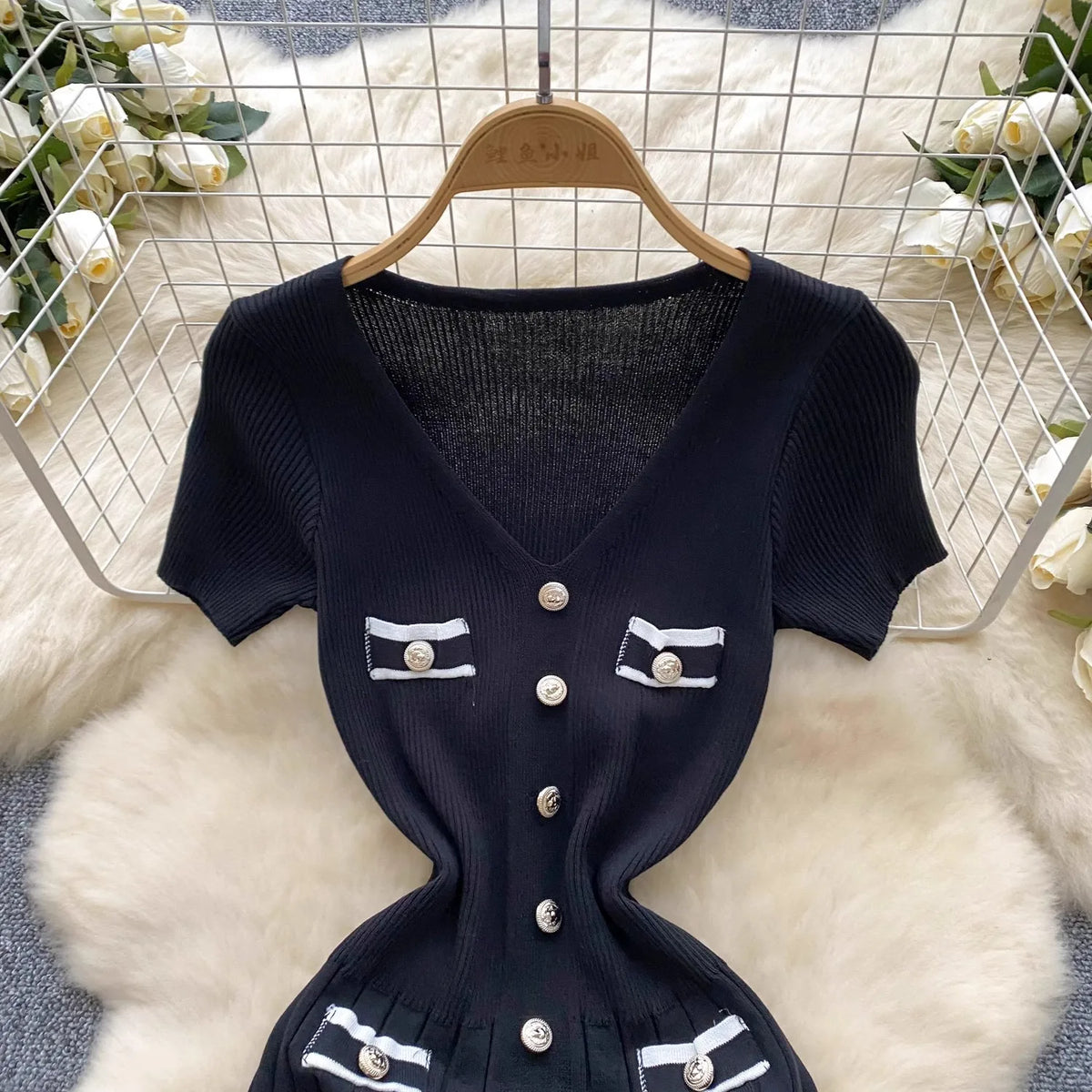 Black Yuoouoo knitted dress with V-neck and button details, featuring stretchy fabric and a relaxed fit, by Corporación Turística.