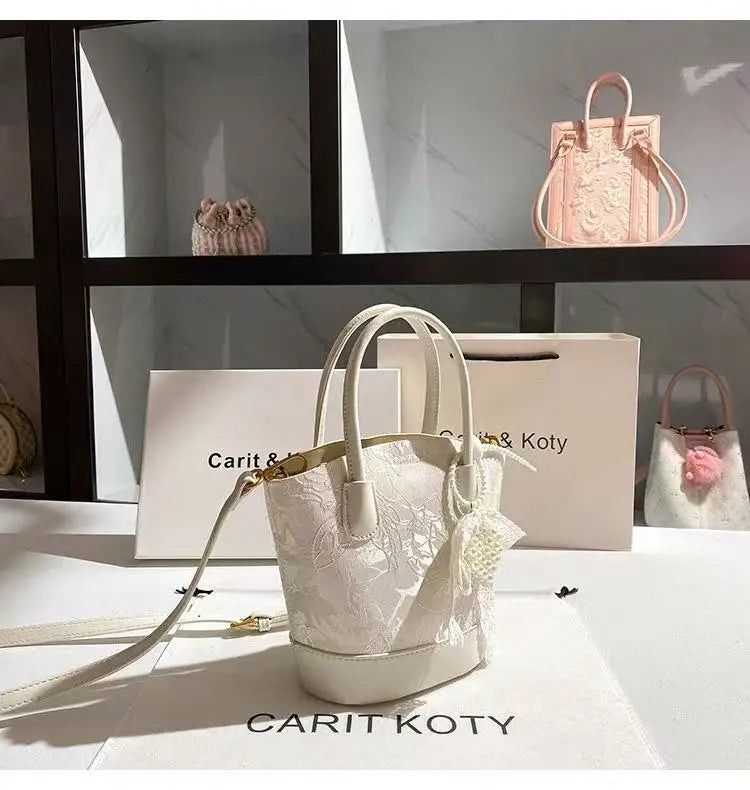 Luxury white embroidered cubo-shaped handbag by Corporación Turística, featuring a stylish modern design and compact size.