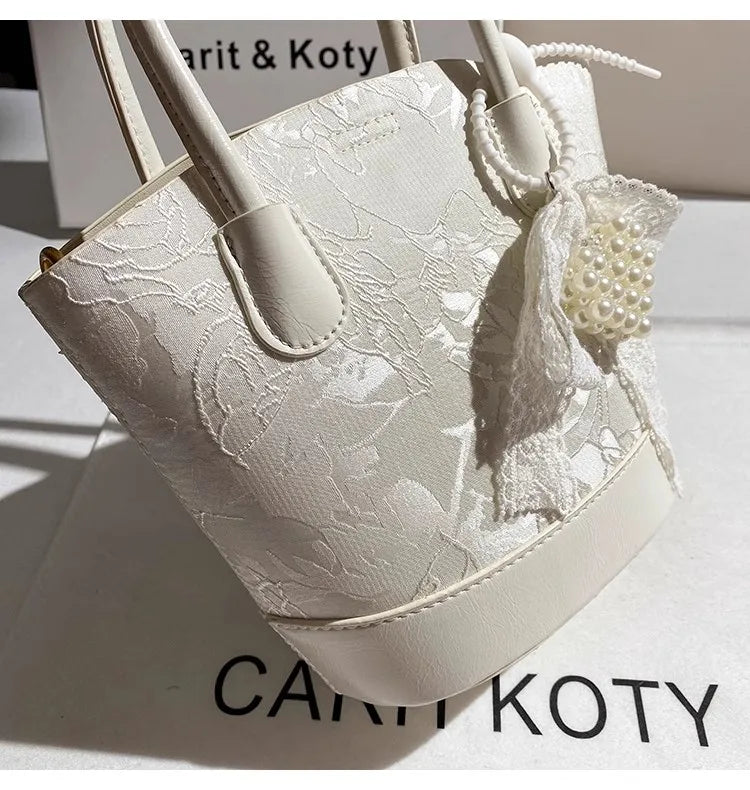 Luxury white embroidered cube-shaped handbag featuring a stylish design, perfect for fashion-forward outfits.