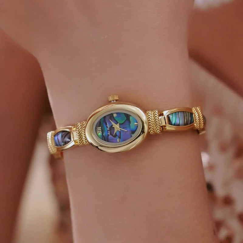 Gold women's bracelet watch with an oval dial, crafted by Corporación Turística, featuring a sleek design and elegant style.