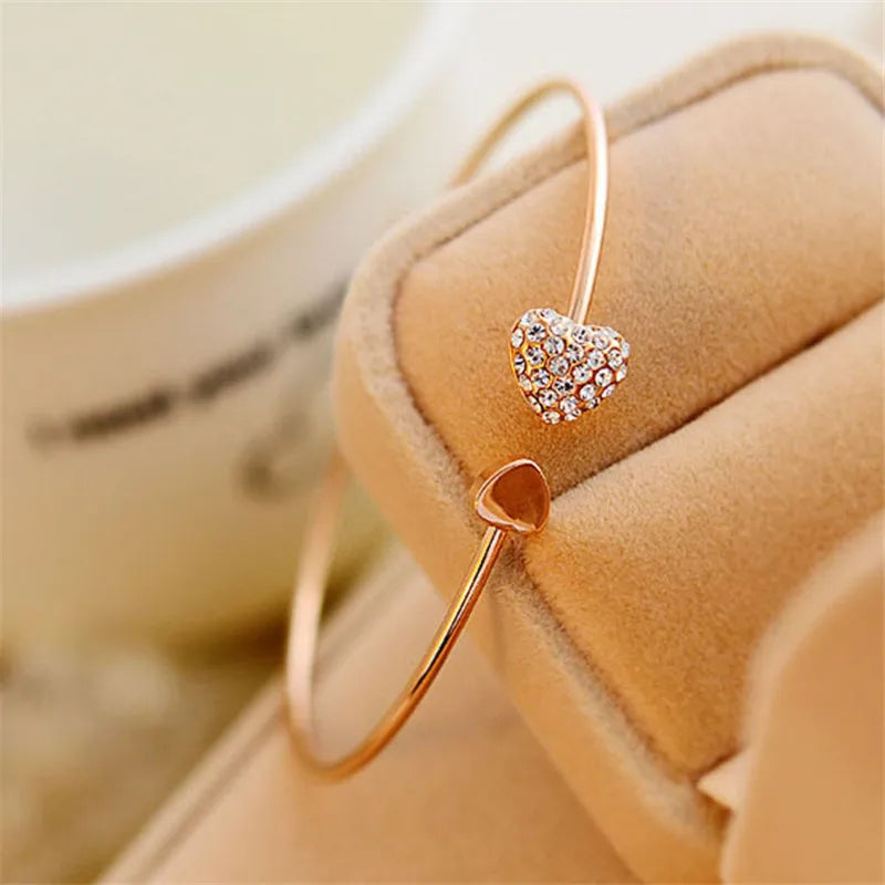 Gold double C bangle bracelet from Corporación Turística, stylish and open-ended jewelry with a sleek design.