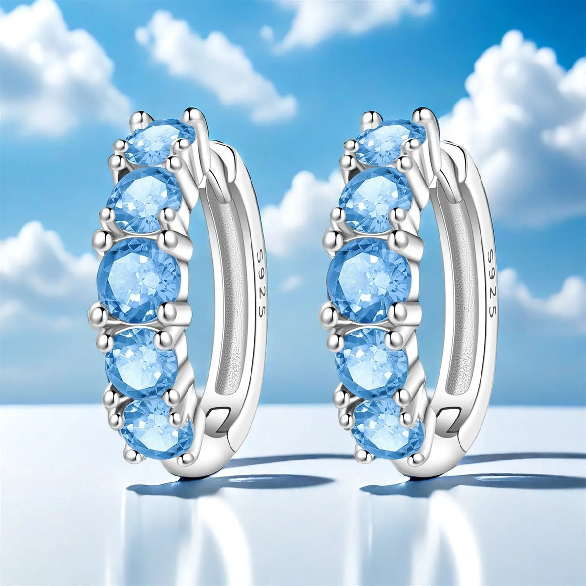Colorful zirconia earrings by Corporación Turística featuring simplified, vibrant gemstone designs on sleek hooks.