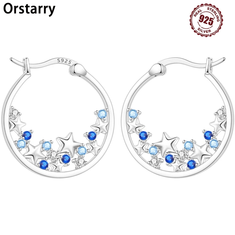 Sterling silver Orstarry earrings with blue cubic zirconia by Corporación Turística, showcasing elegant, sparkling jewelry design.
