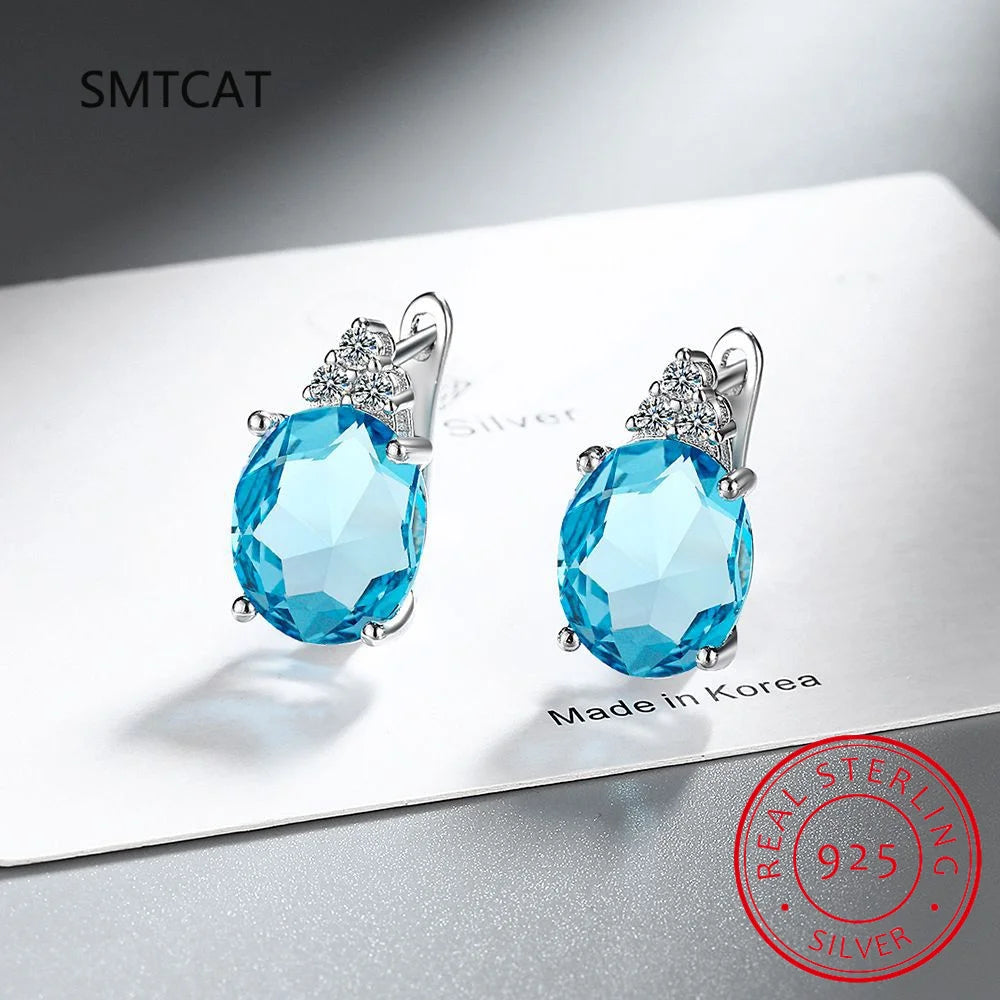 Sterling silver hoop earrings with blue sapphire accents, crafted by Corporación Turística, elegant jewelry for everyday wear.