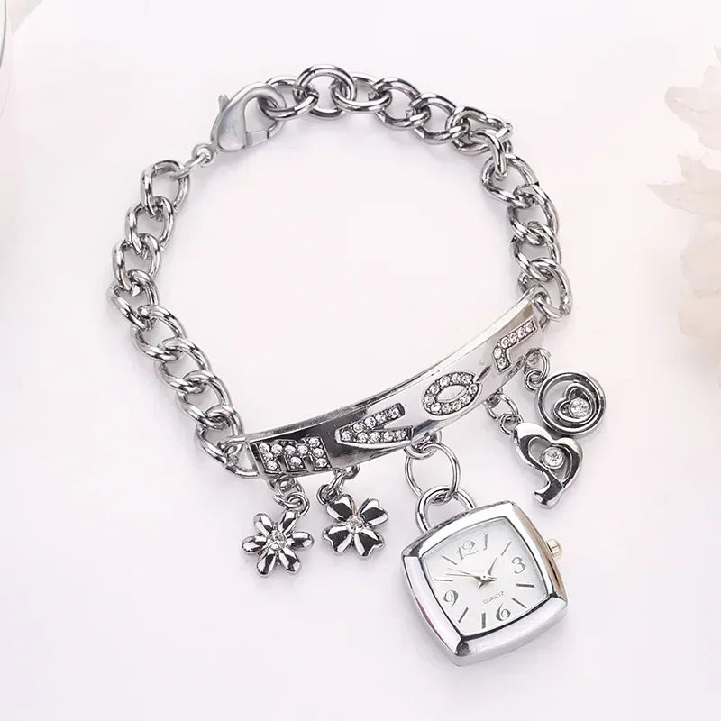 Silver women's letter bracelet watch with chain design by Corporación Turística, close-up of the jewelry on white background.