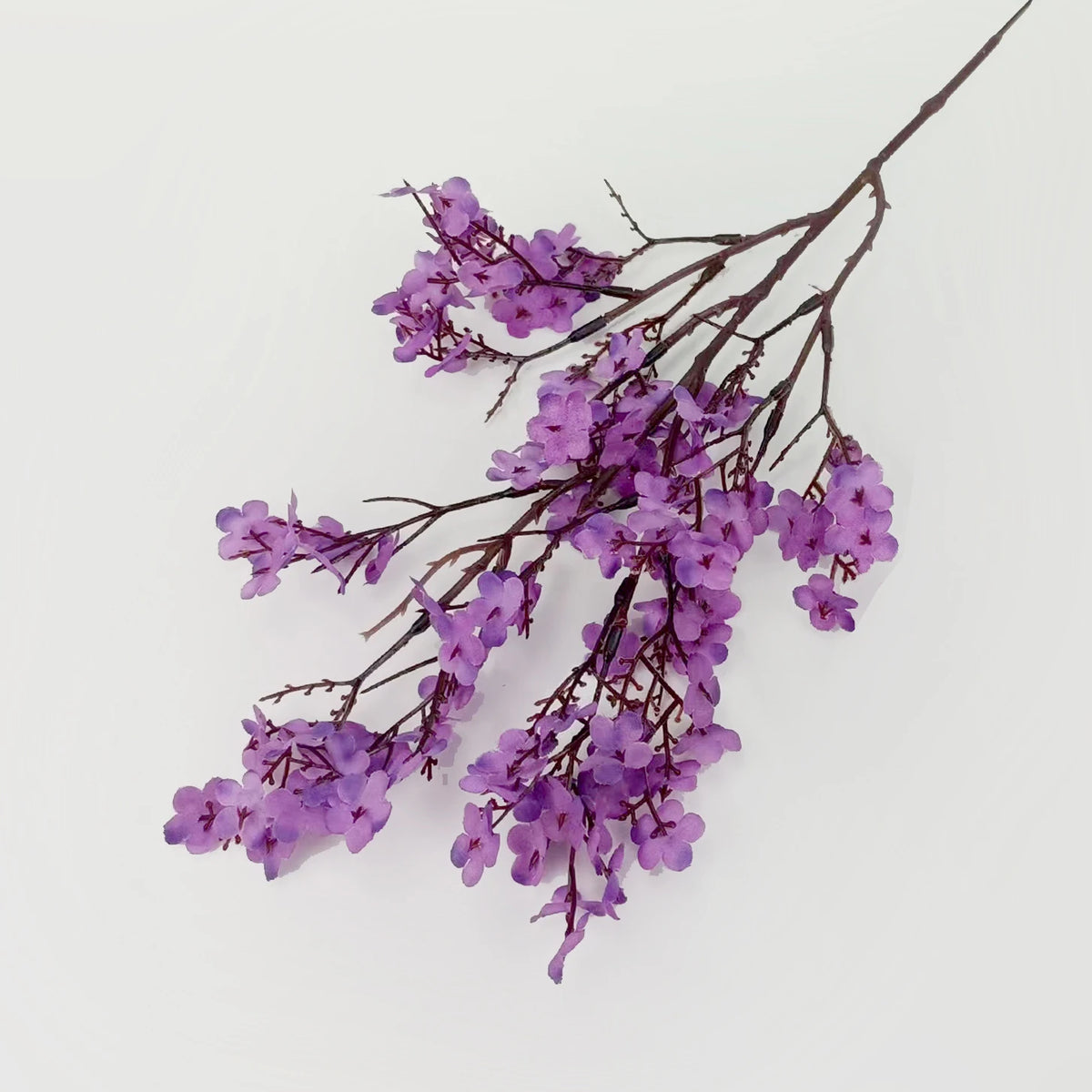 Two artificial Gypsophila flowers in purple, faux floral decor by Corporación Turística.