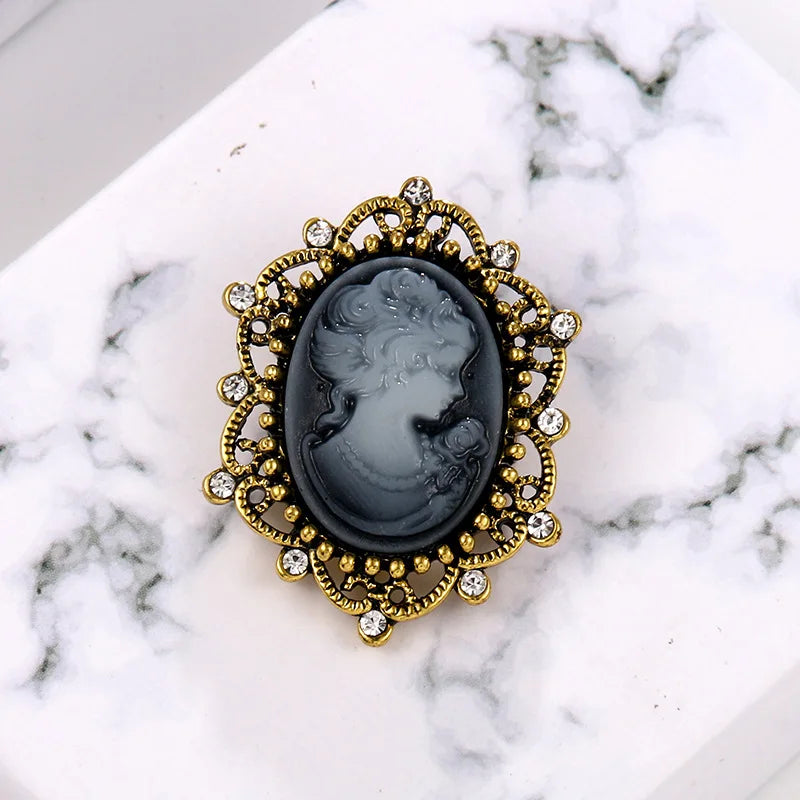 Vint-style queen cameo brooch with imitation diamonds, featuring purple and gold accents, jewelry accessory by Corporación Turística.