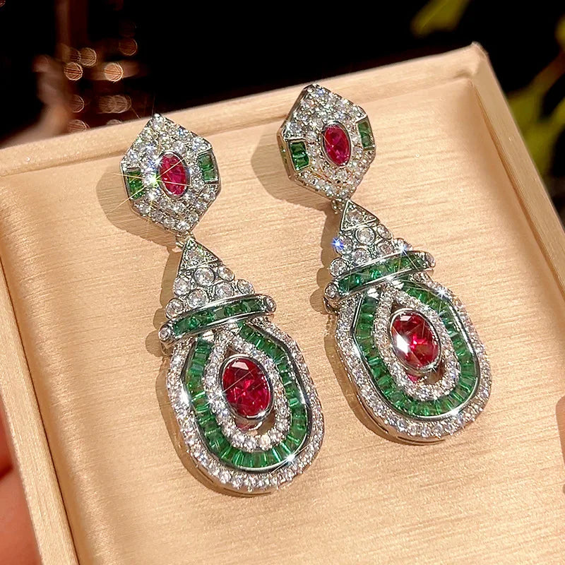 Vintage style dangling earrings with red stud accents from Corporación Turística, showcasing bohemian-inspired fashion jewelry.
