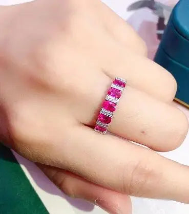 Elegant white cubic zirconia ring for women by Corporación Turística, showcasing a luxurious jewelry design with a red background.