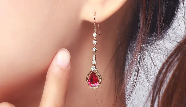 Rose gold 18K ruby drop earrings with natural rubies, elegant jewelry featuring pendant design and sparkling gemstone accents.