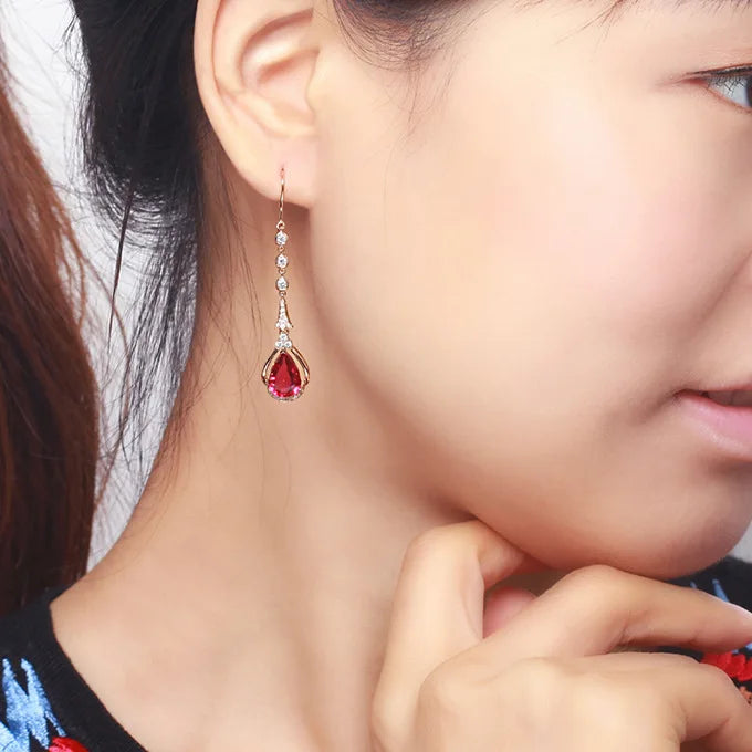 Pink gold ruby drop earrings featuring natural rubies, showcasing elegant jewelry design and vibrant gemstone details.