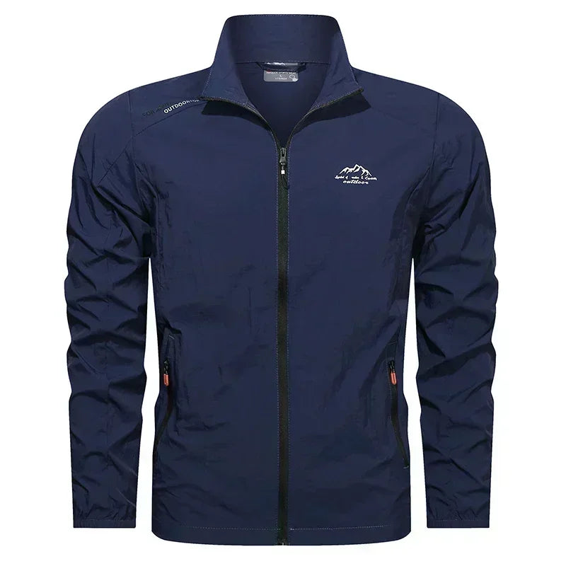 Blue men's lightweight UV protection jacket with pockets, UPF100+ summer windbreaker from Corporación Turística, suitable for outdoor wear.