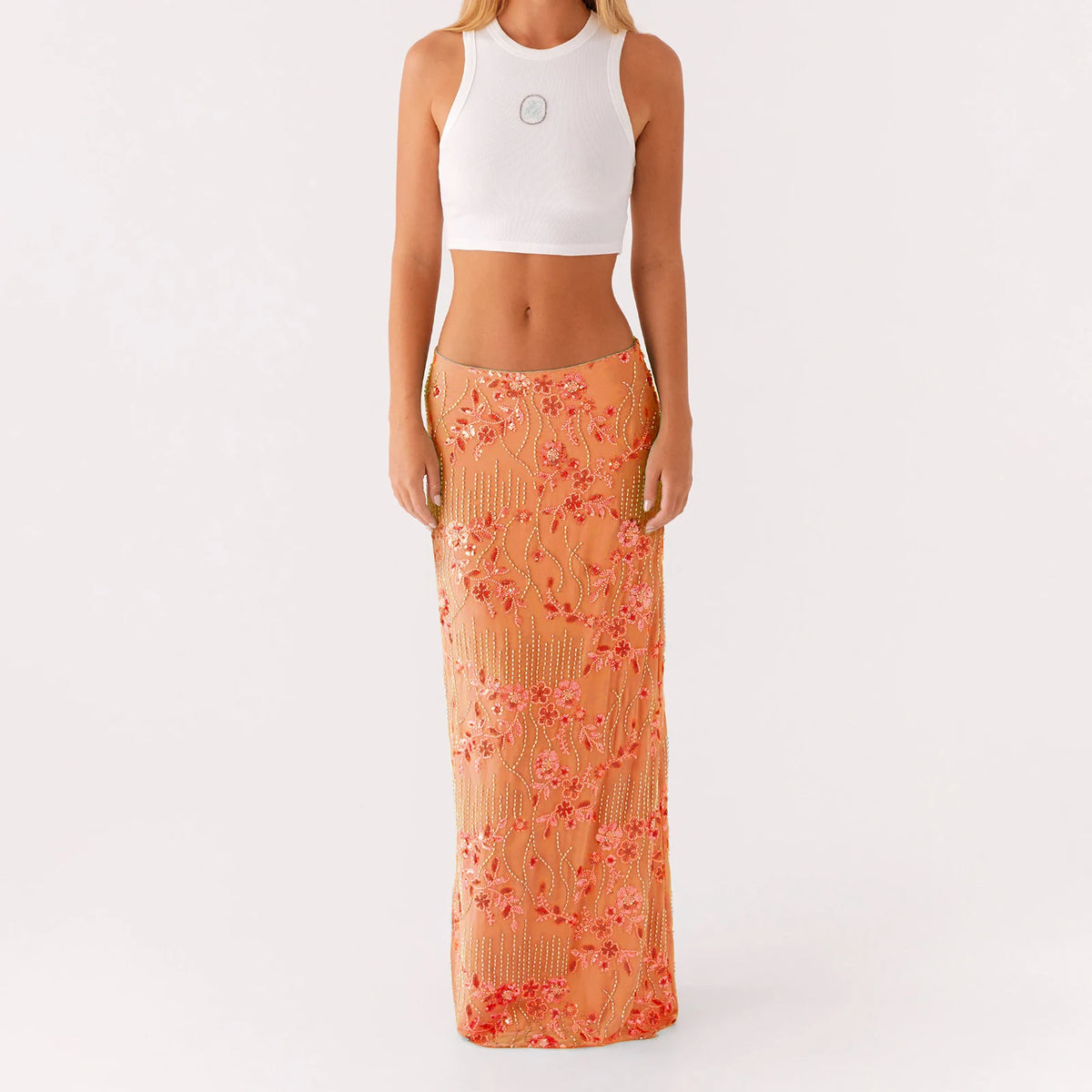Elegant long skirt for women with sequins and beads, featuring a vibrant pink color and flowing fabric design.
