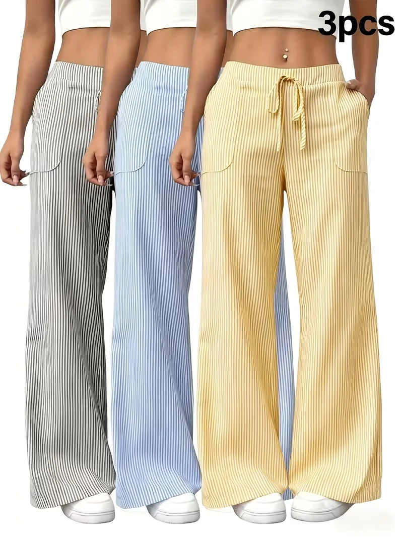 Three-piece women's sports pants set from Corporación Turística, featuring pink athletic joggers and matching tops, laid flat.