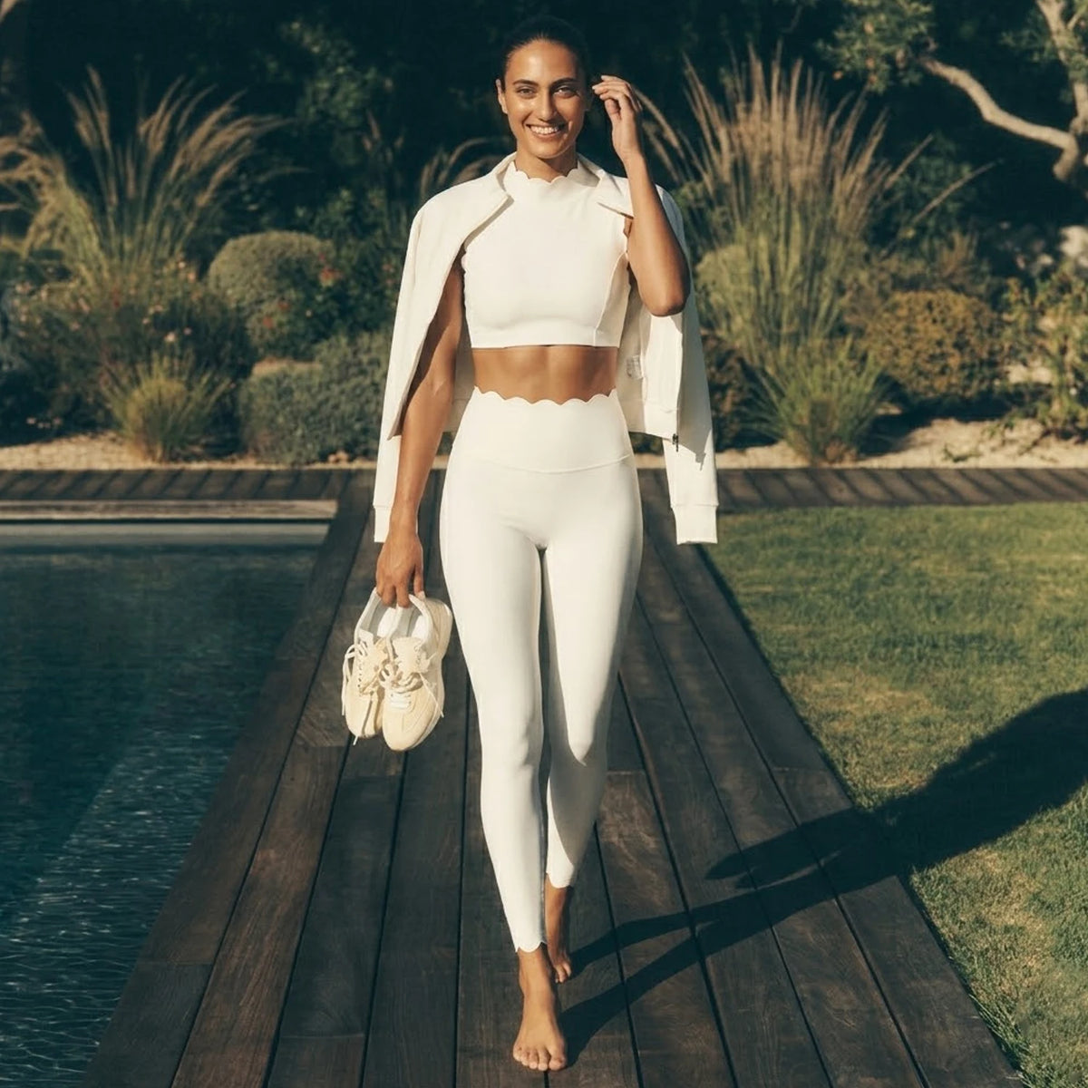 Rose-colored high-waist leggings and sleeveless top set by Corporación Turística, shown on a flat lay with smooth fabric details.