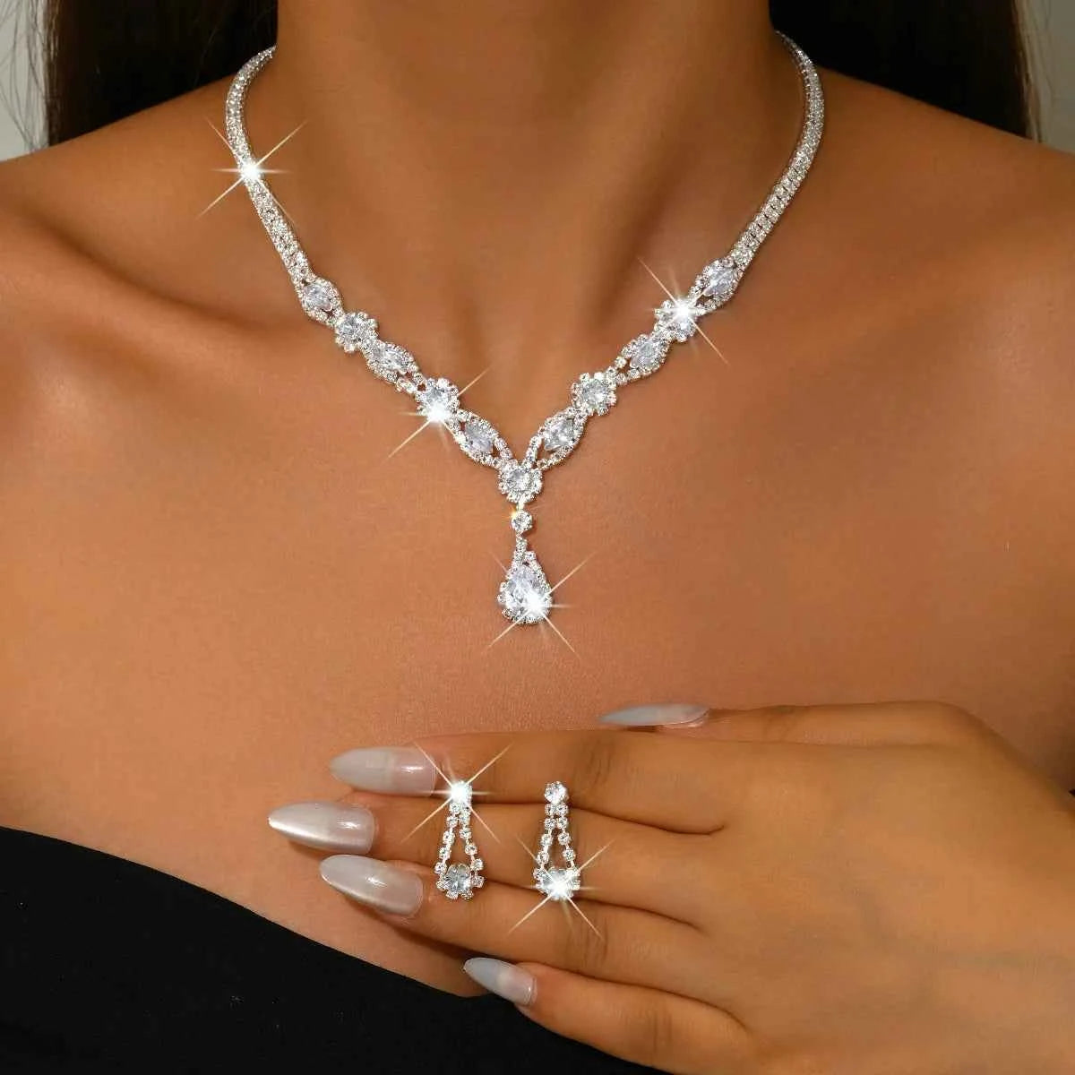 Luxury silver crystal jewelry set with elegant shaped pieces, featuring intricate designs and a polished finish.