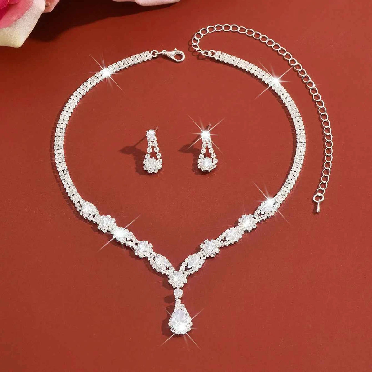 Luxury silver crystal jewelry set featuring elegant designs, including necklaces and earrings with a polished, shiny finish.