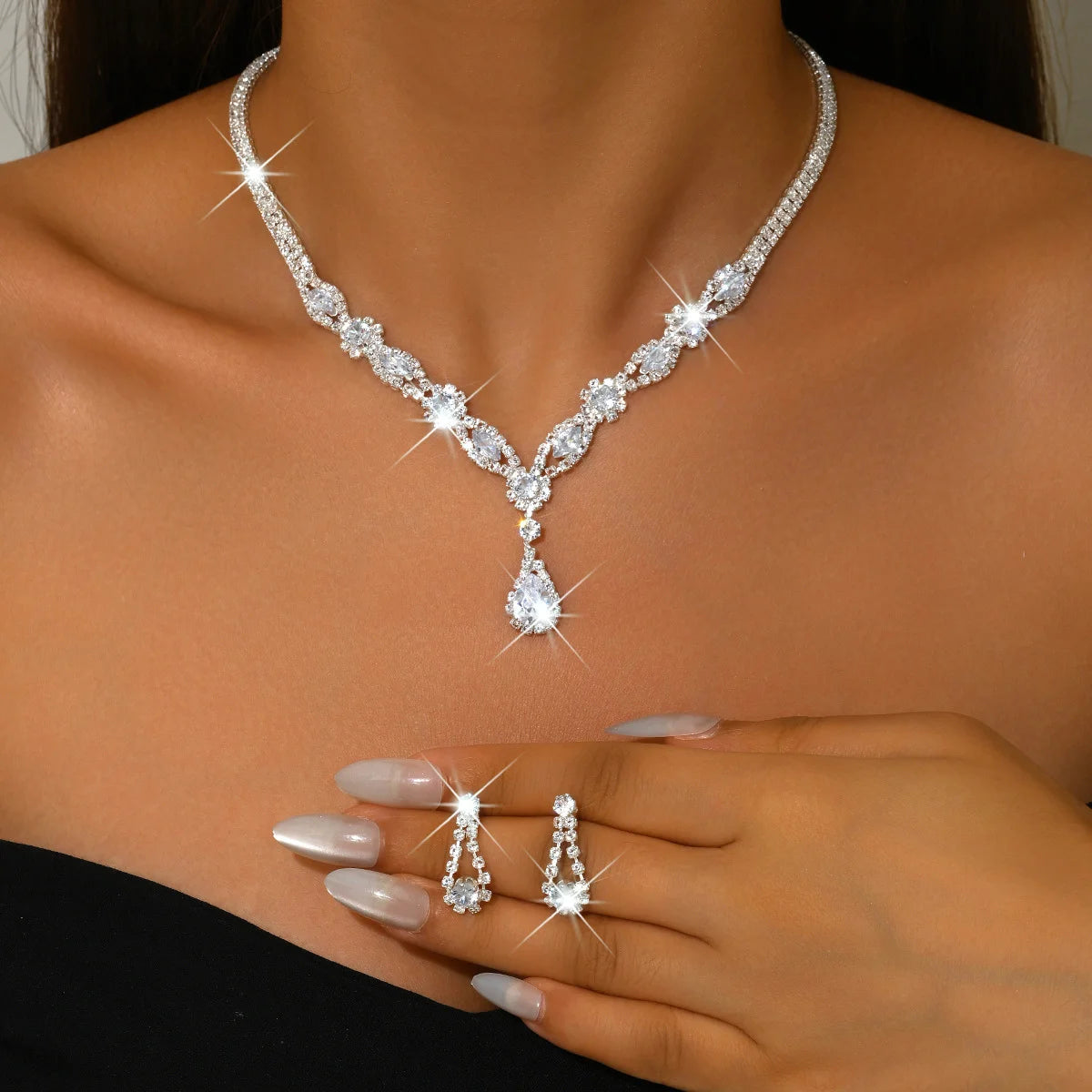 Elegant silver crystal jewelry set with luxurious design and unique shape, featuring necklaces and earrings.