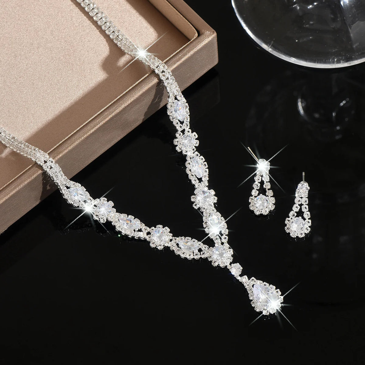 Luxury silver crystal jewelry set with elegant shaped pieces, featuring intricate designs and a polished finish.