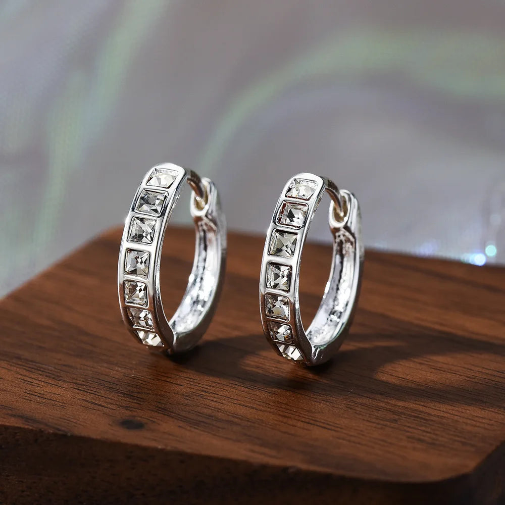 Sterling silver earrings with sparkling cubic zirconia stones, showcasing elegant, shiny jewelry design.