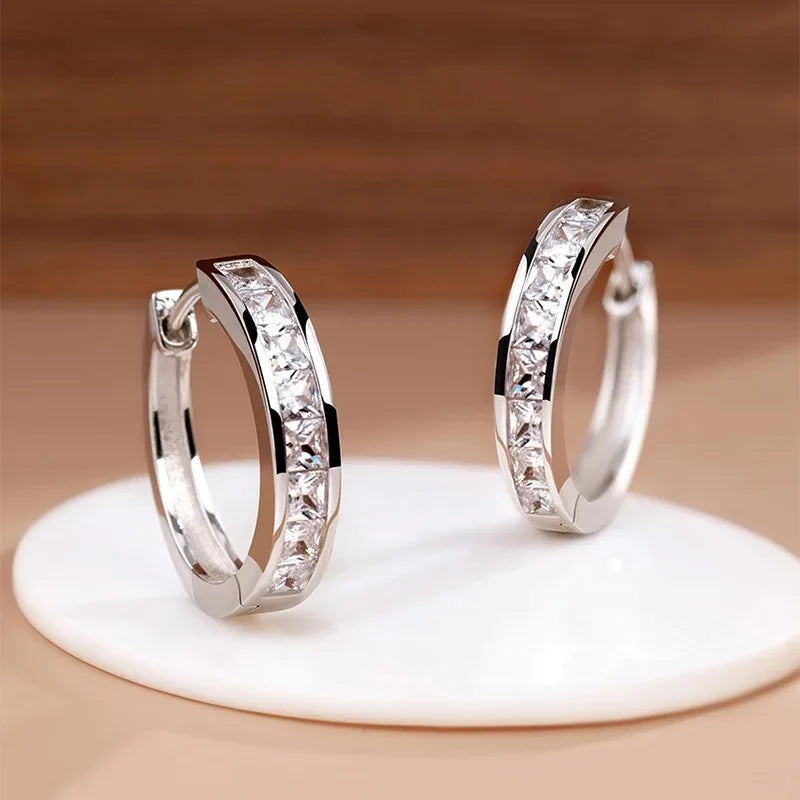 Sterling silver earrings with sparkling cubic zirconia stones, featuring elegant design and bright, shiny finish.
