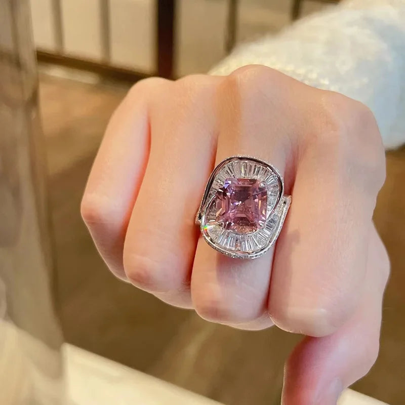 Pink quartz charms and floral wedding rings in silver, showcasing intricate jewelry designs by Corporación Turística.