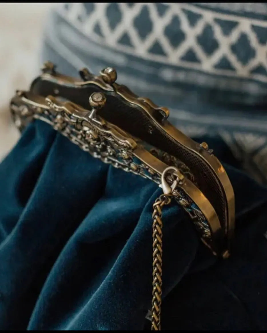 Vintage velvet clutch bag from Corporación Turística with a secure metal clasp, solid color and elegant design.
