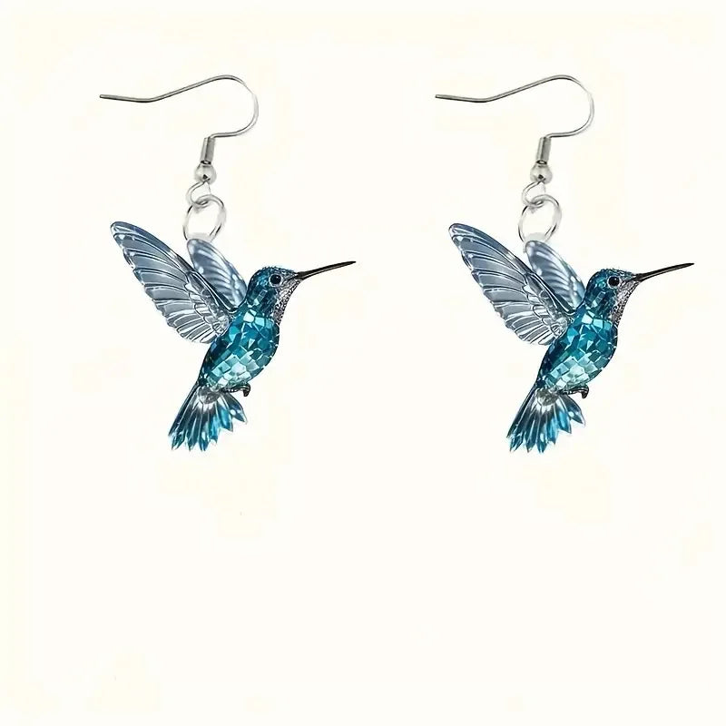 Acrylic hummingbird earrings featuring vibrant colors and detailed feather design, crafted by Corporación Turística.