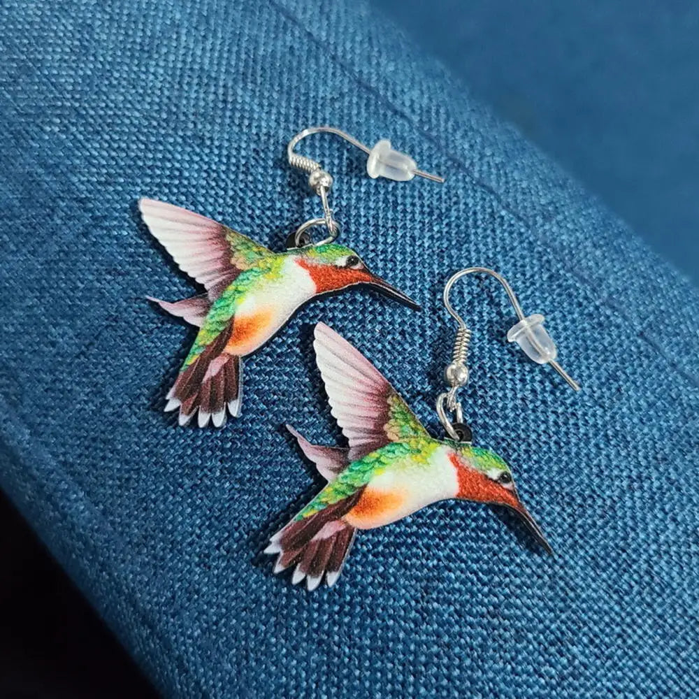 Acrílicos pendientes de colibrí con forma de ave en colores vibrantes, con diseño artístico y detalles delicados.