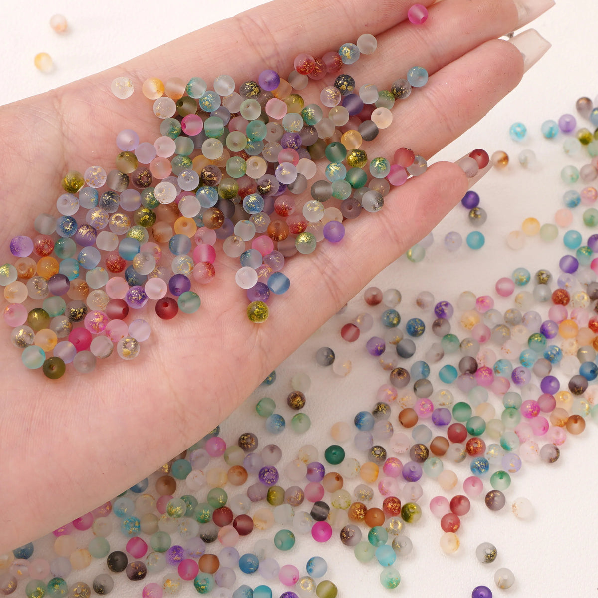 Set of 100 gold-splashed glass rice beads for jewelry making, from Corporación Turística, featuring small 4mm colorful glass beads.