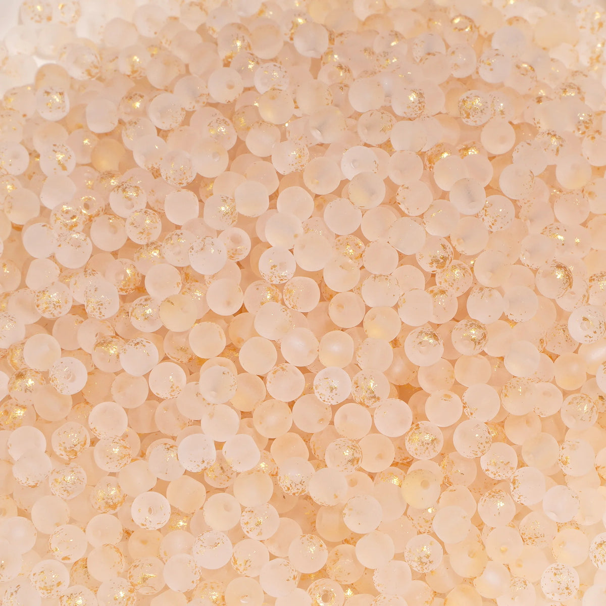 Set of 100 gold-splashed 4mm glass rice beads for jewelry making from Corporación Turística.