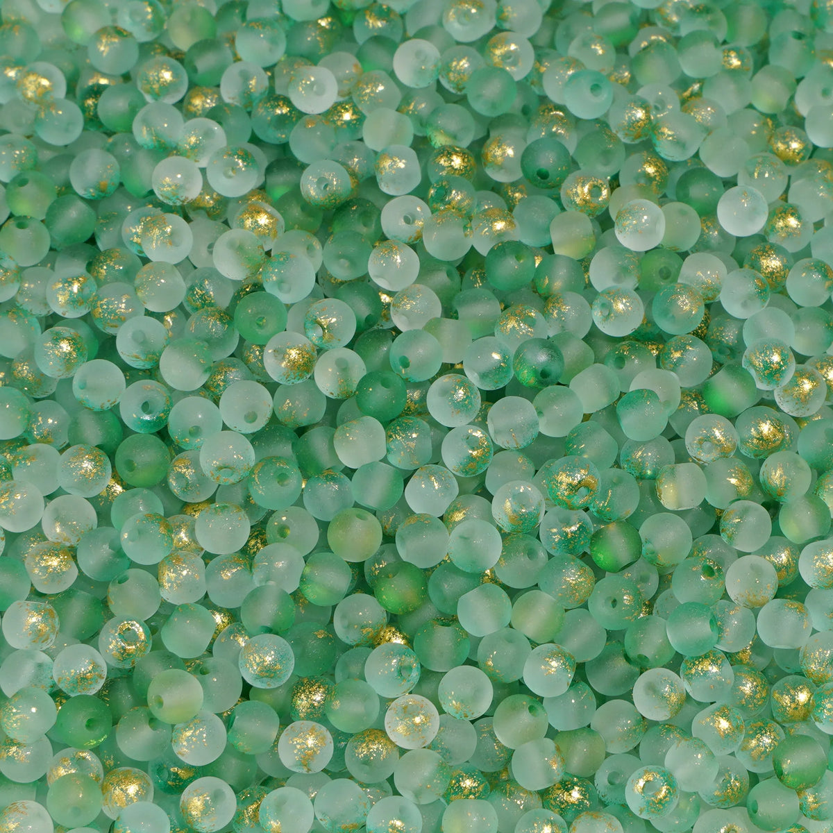 Set of 100 gold-splashed glass rice beads from Corporación Turística, 4mm, with a shiny, speckled finish for jewelry making.