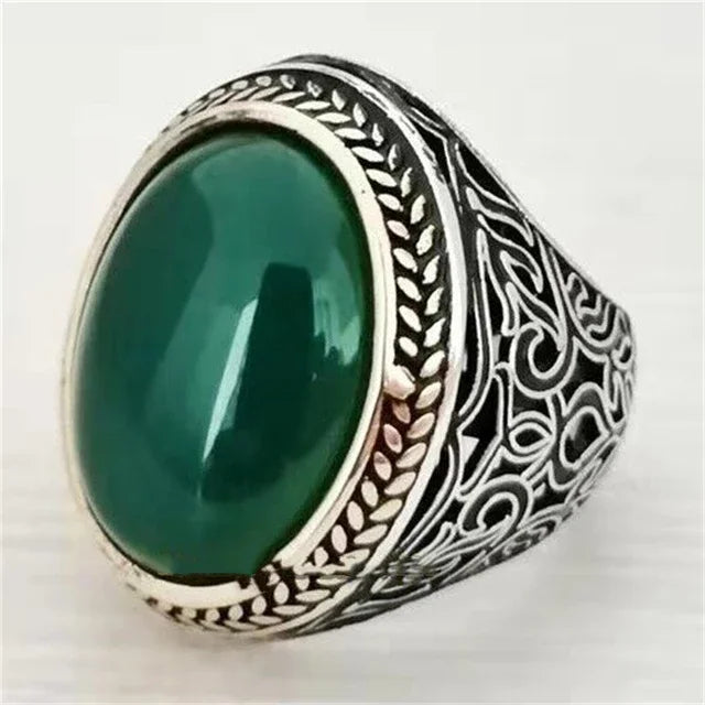 Luxury emerald ring by Corporación Turística with intricate gemstone inlays, designed for elegant wear on the shoulder.