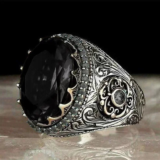 Luxury emerald ring with intricate gemstone inlays, designed for the shoulder, showcasing detailed craftsmanship and vibrant green color.