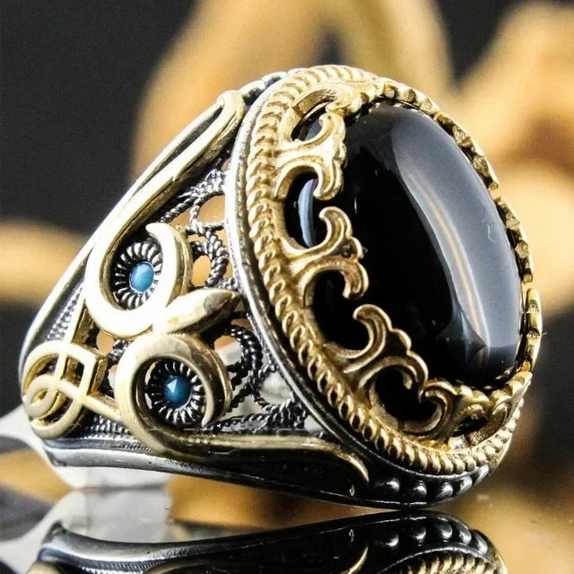 Luxury emerald ring with intricate gemstone inlays, featuring a bold design suitable for special occasions.