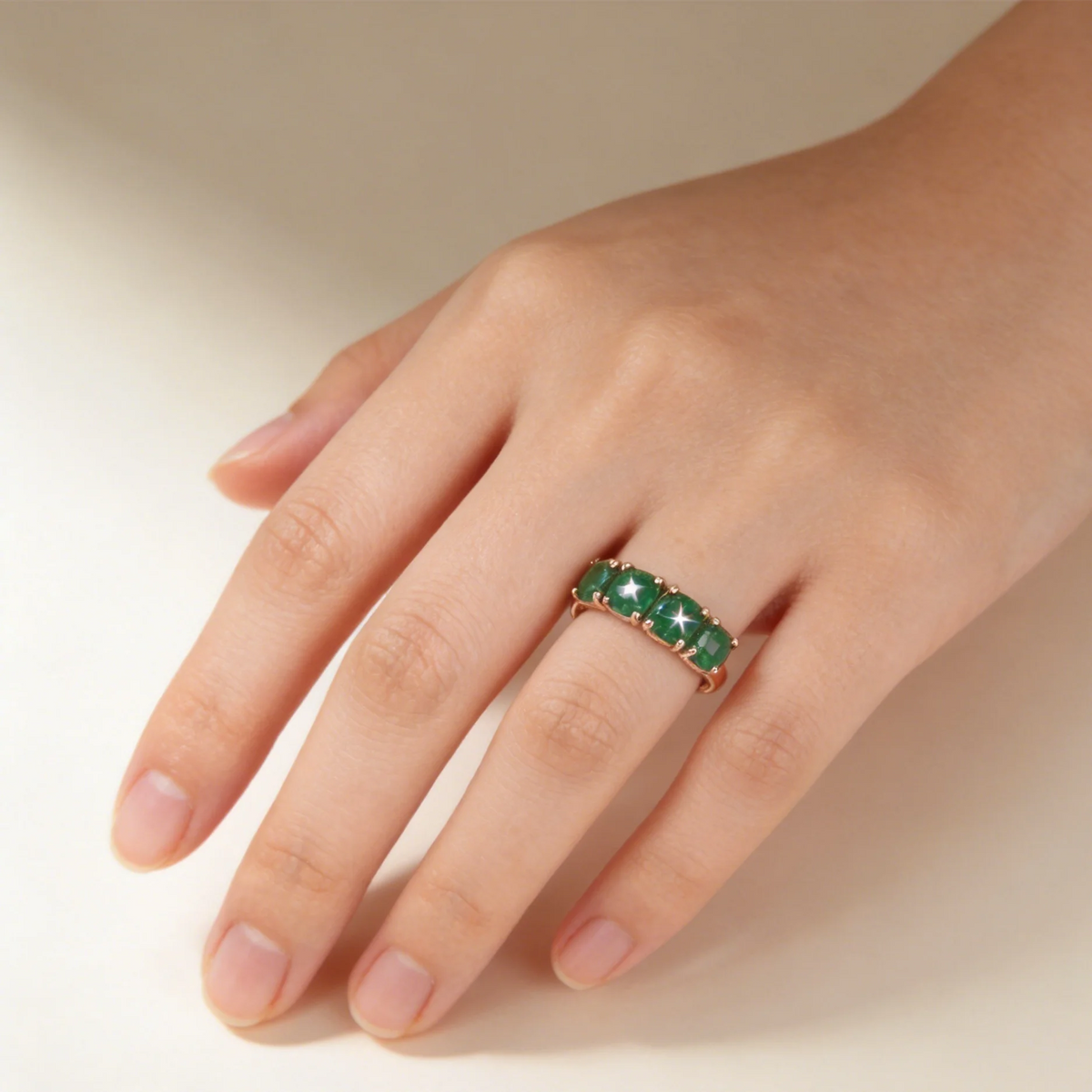 Elegant 18K rose gold women's ring with a green emerald gemstone, showcasing intricate design and craftsmanship.