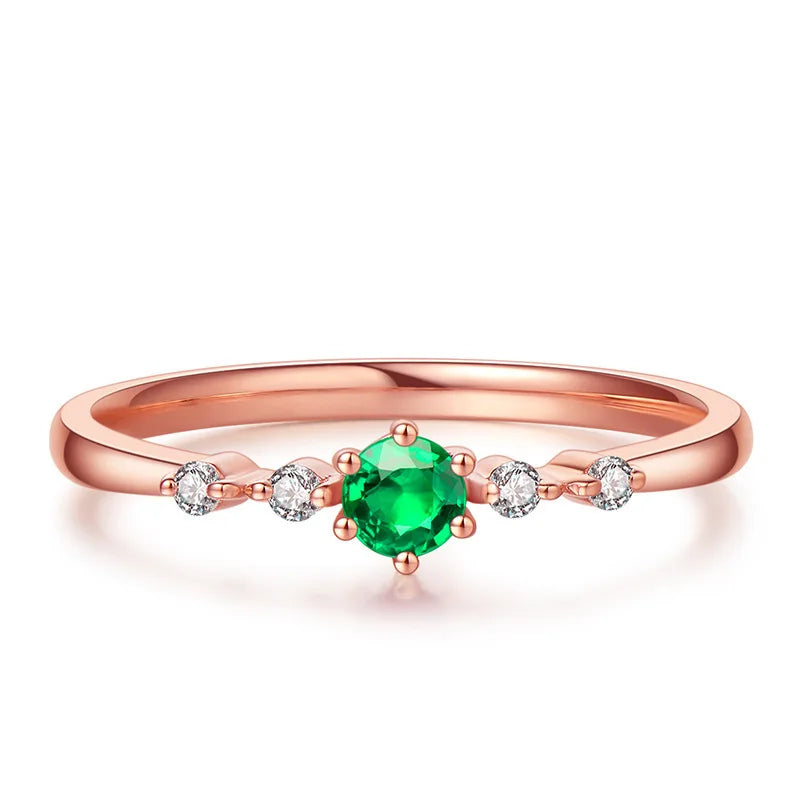 Set of natural emerald and rose gold rings for women, featuring band-style design and vibrant green gemstones.