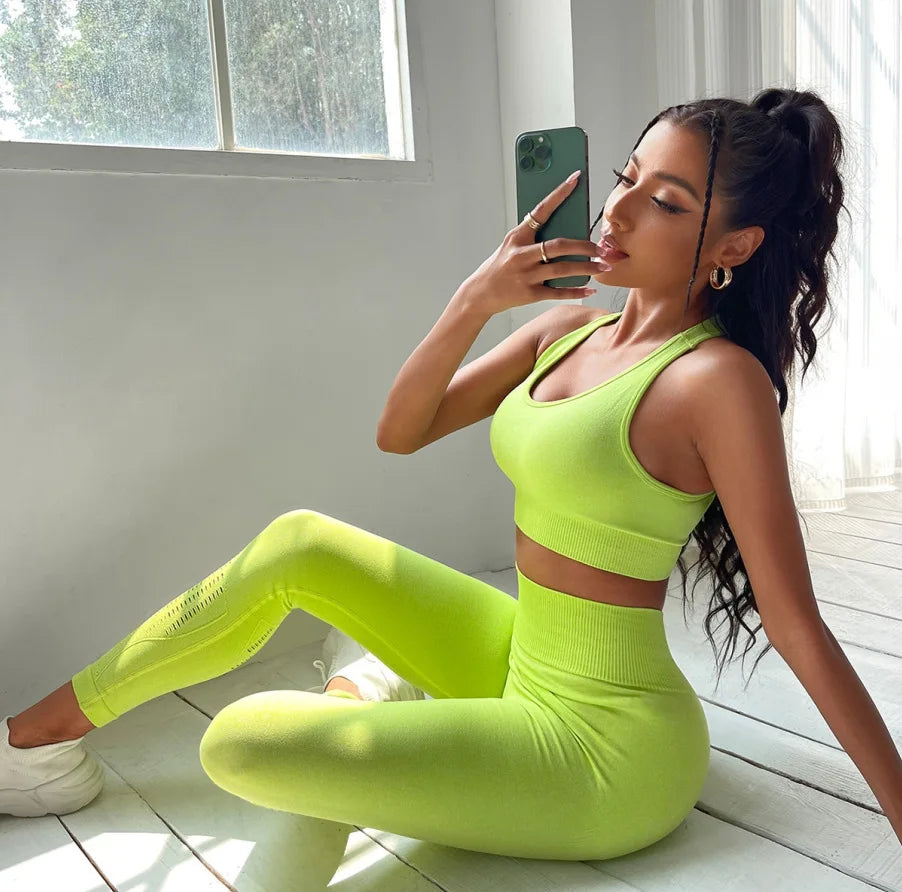 Seamless green yoga sports set for women by Corporación Turística, includes sports bra and leggings, on a white background.
