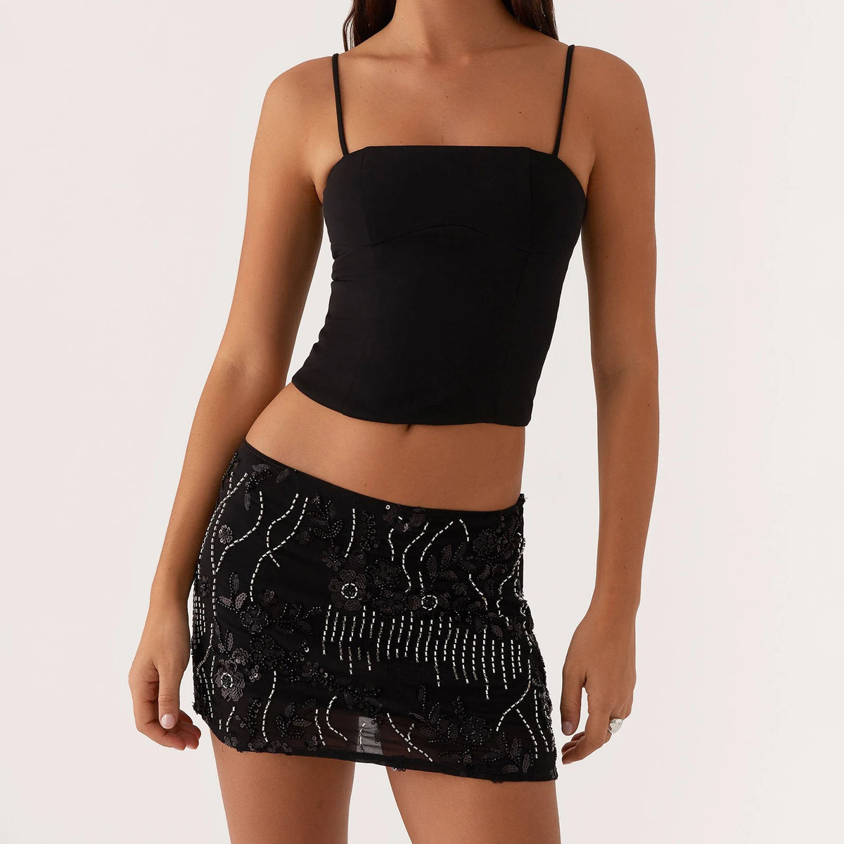 Green sequin miniskirt for women by Corporación Turística, close-up of shiny, fitted mini skirt with a waistband detail.