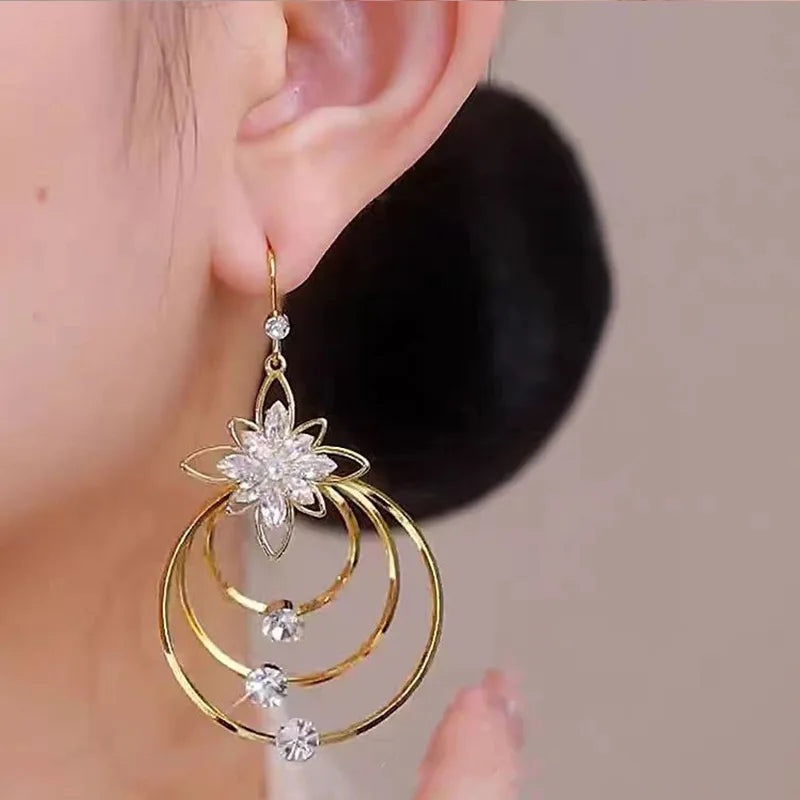 Elegant floral and circle design earrings by Corporación Turística, featuring intricate gold-tone accents and stylish craftsmanship.