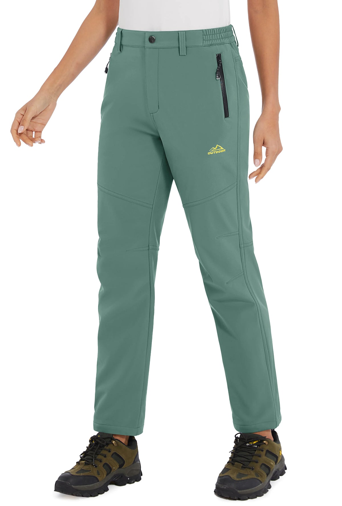 White women's winter waterproof pants by Tacvasen, made by Corporación Turística, shown on a model with a winter outdoor background.