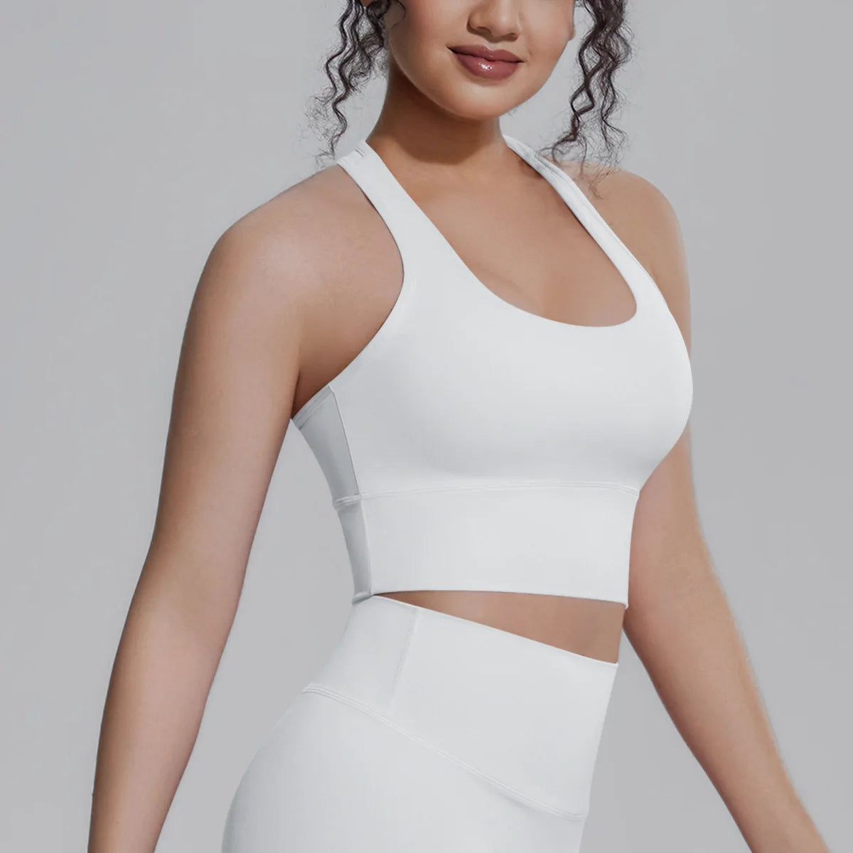 White women's sports top by Corporación Turística, designed for fitness and running activities, with a sleek athletic fit.