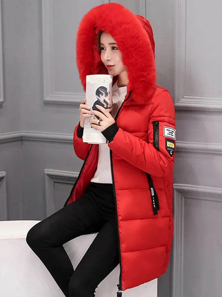 Long black winter coat for women with hood and high collar, by Corporación Turística, shown hanging with front view.